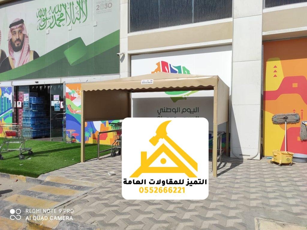 مظلة قماشية بيج على هيكل معدني تغطي مدخل محل تجاري