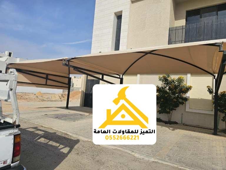 مظلة سيارات قماشية أمام فيلا وسيارة نقل أسفلها