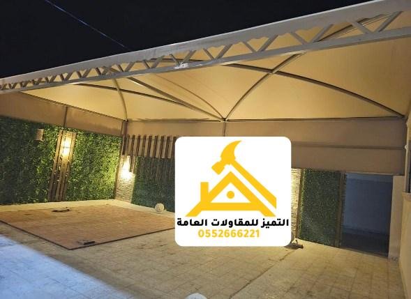 مظلة سيارة بهيكل جمالوني وإضاءة ليلية فوق مدخل منزل