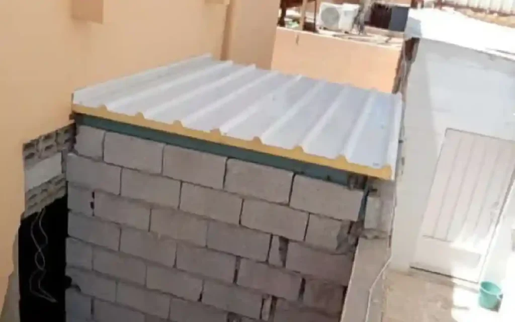 حافة ألواح سقف ساندوتش بانل فوق جدار بلوك يظهر فيها مقطع اللوح