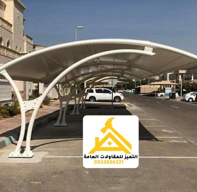 صف مظلات مواقف مقوّسة بيضاء بجوار مبنى