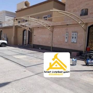 مظلة سيارة قماشية مقوّسة بجانب منزل