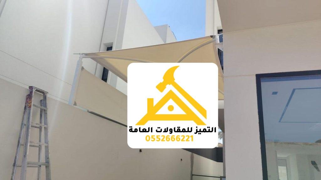 مظلة قماشية معلّقة فوق مدخل فيلا مع سلّم العمل