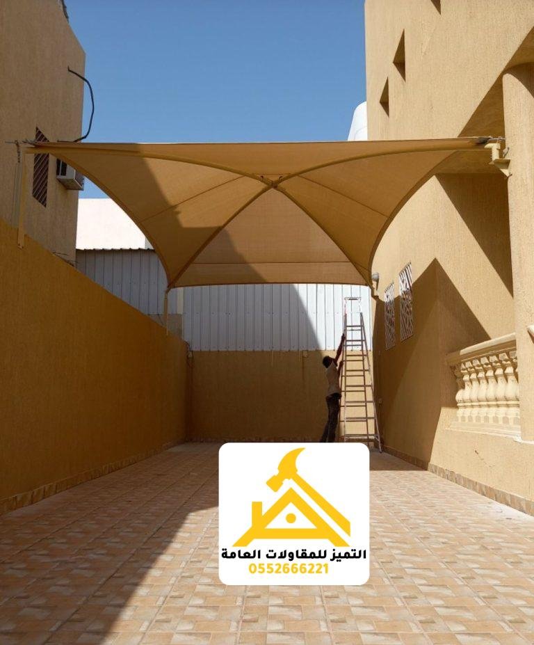 مظلة قماش على شكل X فوق فناء ضيق