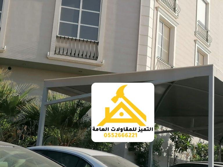 مظلة مواقف مسطحة داكنة فوق سيارات أمام عمارة سكنية